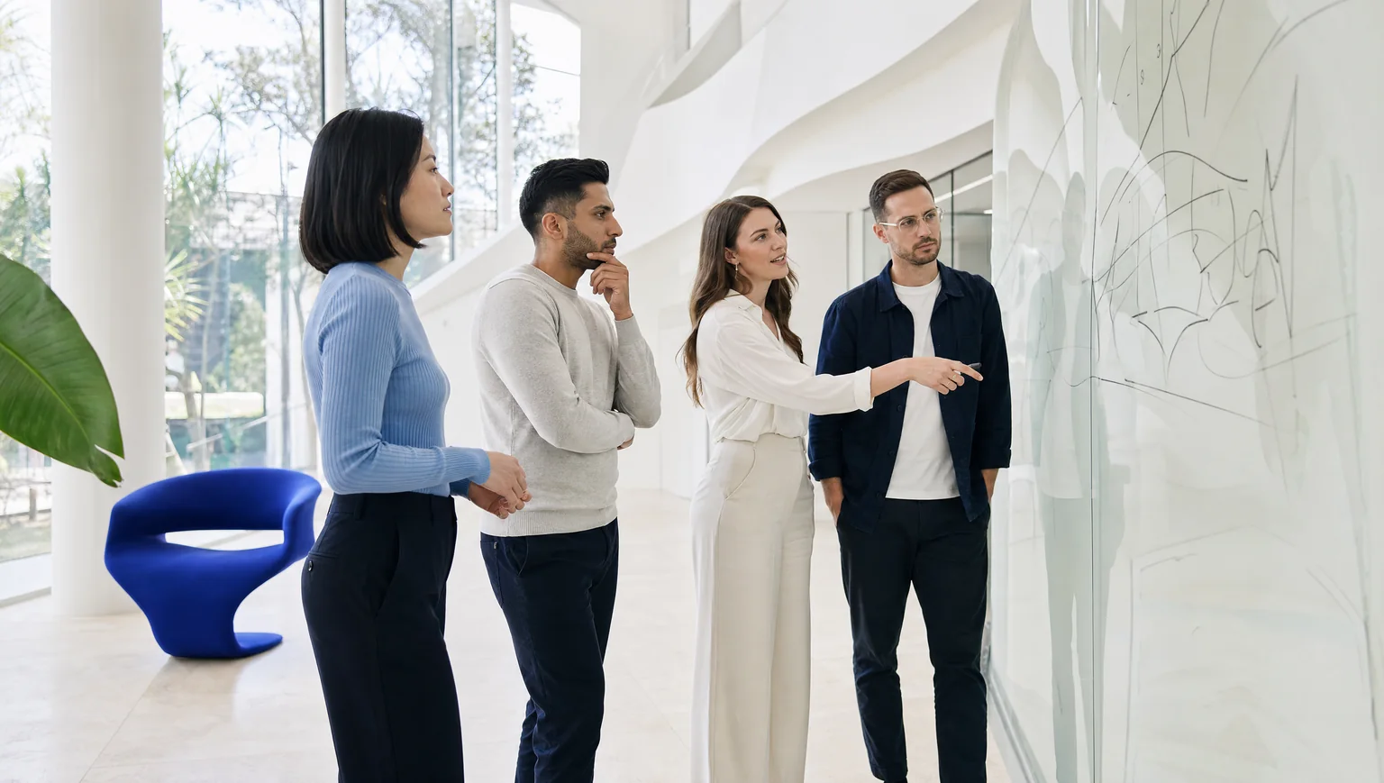 A business team collaborates on a design during a review, showcasing effective teamwork with caqa-crm.